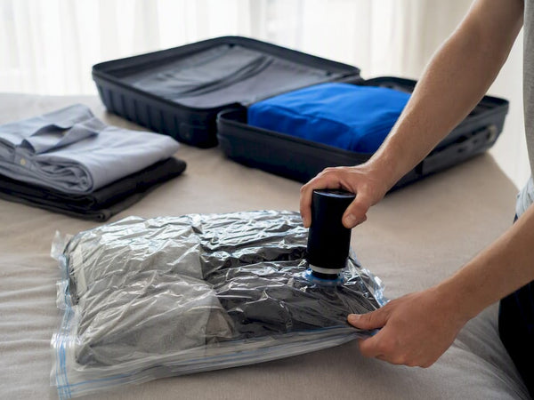 Hands compressing clothes in vacuum bag