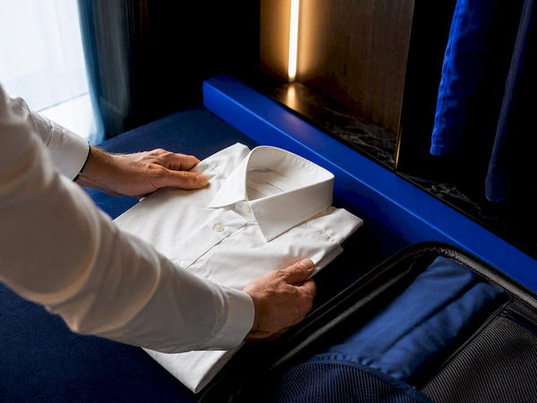 Hands folding a dress shirt for travel