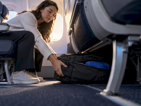 Backpack checked beneath an airplane seat