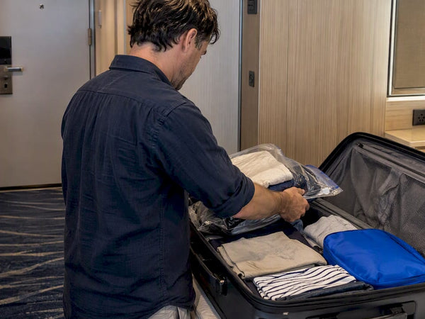 Traveler packing compressed clothes into carry-on